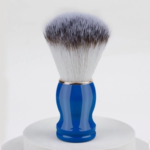 Detail van blauwe scheerkwast met zachte synthetische haren op een witte basis