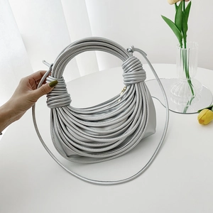 Silver woven knotted top handle bag with metallic finish and long crossbody strap