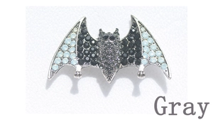 Macro shot of silver bat brooch featuring intricate grey and blue rhinestones