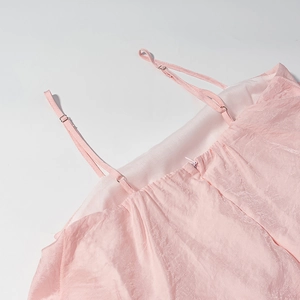 Détail de robe rose à volants montrant bretelles réglables et fermeture éclair dos