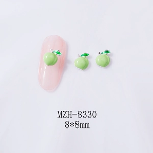 Macro detail of 8x8mm green apple nail charm with silver border on a pink nail tip