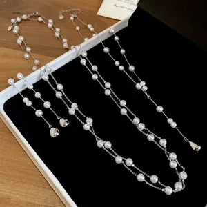Ensemble élégant de colliers et boucles d'oreilles en perles vintage sur plateau bijoux
