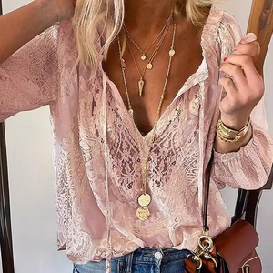 Elegante blusa de encaje rosa con cuello en V, manga larga y detalles de borlas bohemias