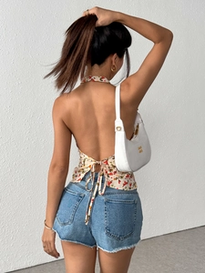 Floral halter top with open back and bow tie paired with light blue denim shorts