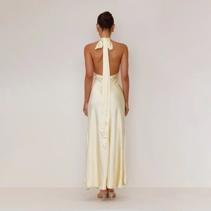 Detail of elegant backless halter dress with long satin ribbon ties in pale yellow finish