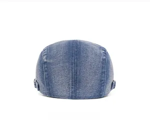 Detail of denim beret back view showing adjustable metal buckles and washed texture