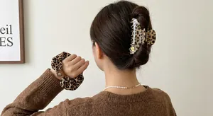Leopard print fabric bow and resin shark clip hair accessory set on a woman's brown hair