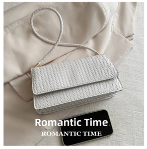 Detail of white woven PU leather handbag with gold buckle and braided shoulder strap