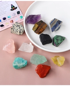 Flat lay of natural healing crystals including Amethyst and Tiger Eye on a pink surface