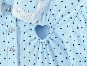 Detail of light blue polka dot romper with lace collar, bow buttons and heart cutout