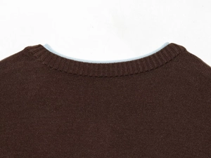 Detail of round neckline with ribbed knitting and blue contrast inner collar