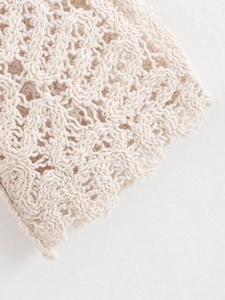 Gros plan sur la texture en maille crochet blanc cassé et les motifs ajourés