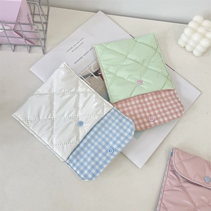 Close-up of quilted storage pouch showing glossy finish and checkered fabric lining