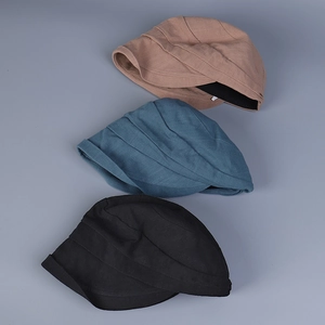 Detail view of cotton caps with pleated texture in khaki, blue, and black colors