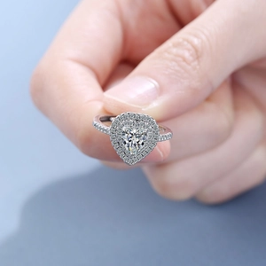 Sparkling halo heart cut diamond ring in polished silver setting shown on hand