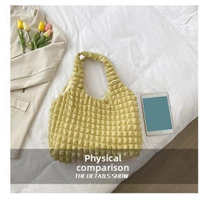 Detailed macro view of yellow popcorn texture fabric on a stylish casual bucket handbag
