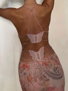 Detail of cross-back straps with lace butterfly appliques on a pink paisley mesh dress