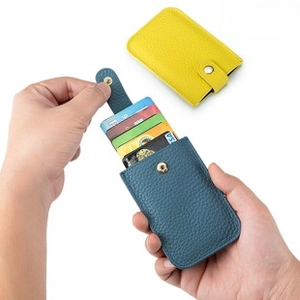 Detail of slim leather card holder showing convenient pop-up slide card extraction function