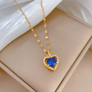 Macro detail of heart necklace featuring blue sapphire stone and micro-pave diamonds
