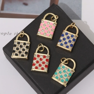 Macro view of gold plated padlock pendants with colorful checkered enamel and cubic zirconia