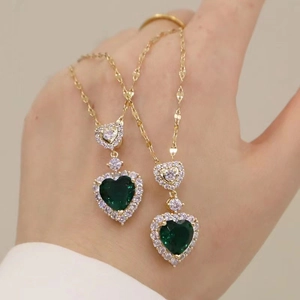 18K gold heart necklace with emerald green stone and sparkling zircon border