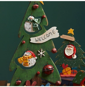 Detail of wooden Christmas tree decor with snowman, metal bell and welcome sign