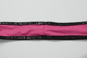 Detailed close-up of pink mesh dress featuring black leather-like trim and flat-seam stitching