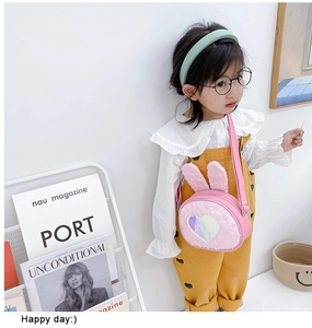 Girl wearing a pink cartoon rabbit sequin crossbody bag with heart details and cute ears