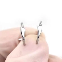 Close-up of non-pierced silver U-shaped nose ring with a minimalist triangle detail