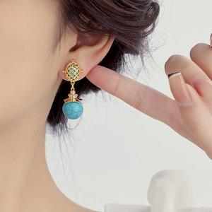 Elegant gold mesh long drop earrings featuring turquoise beads on a female model