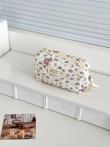 Detail of quilted makeup bag with purple floral bear print and mood quote tag