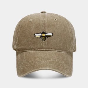 Detailed embroidery of a small bee on a vintage washed khaki cotton baseball cap