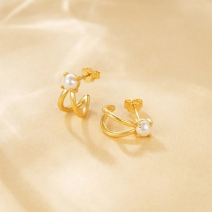 Macro view of S925 hallmark on gold plated C-shaped pearl earrings with CZ accents