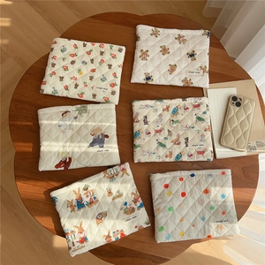 Detailed view of quilted cotton makeup bags with cute animal prints on a wooden table
