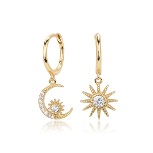 Detailed macro of gold plated asymmetric star and moon hoop earrings with cubic zirconia