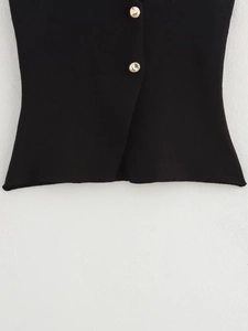 Close-up of black knitted fabric with textured weave and decorative golden buttons