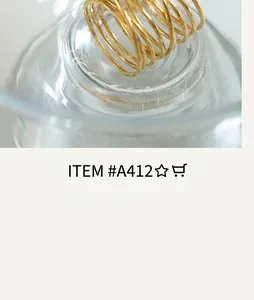 Macro shot of gold-plated spiral multi-layer ring resting on elegant glassware