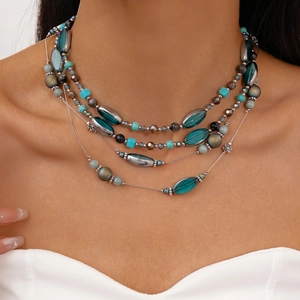 Nahaufnahme der mehrlagigen Boho-Perlenkette mit türkisen und blauen geometrischen Perlen