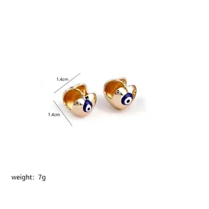 Detailed view of heart-shaped gold earrings with evil eye pattern and 1.4cm size