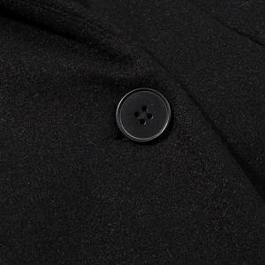 Gros plan de boutons noirs à quatre trous sur un manteau en laine élégant et cintré