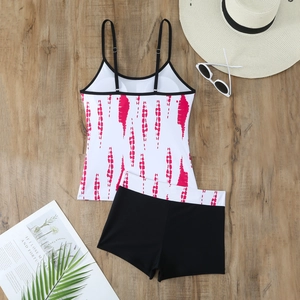 Flat lay of a two-piece tankini set with pink tie-dye top and black boy-cut shorts