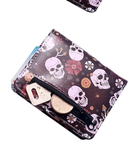 Close-up of gothic skull mushroom print wallet with zipper holding coins and keys