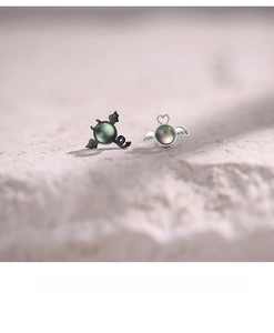 Macro view of asymmetrical angel and demon stud earrings with iridescent shell inlay
