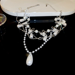 Detailed macro of layered necklace with sparkling rhinestones and drop pearls on black