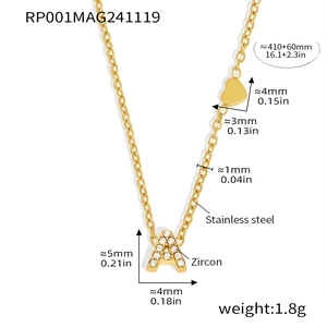 Detail of gold letter A necklace with zircon inlay and small heart charm on white background