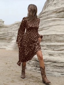 Detail of leopard print maxi dress with high neck and long sleeves styled with cowboy boots