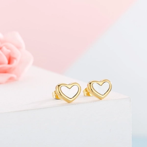 Macro detail of gold heart stud earrings with white shell inlay and polished finish