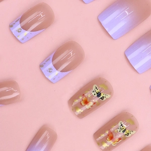 Detailed view of purple gradient press-on nails with butterfly patterns and gold foil