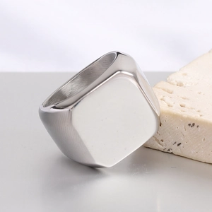Detail of square silver ring with polished finish and brushed inner texture on stone pedestal