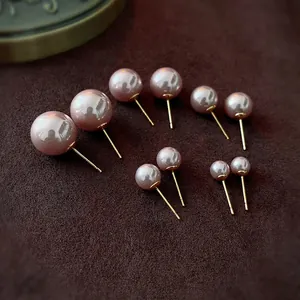 Elegant set of six pairs of pink faux pearl stud earrings in various sizes with gold posts